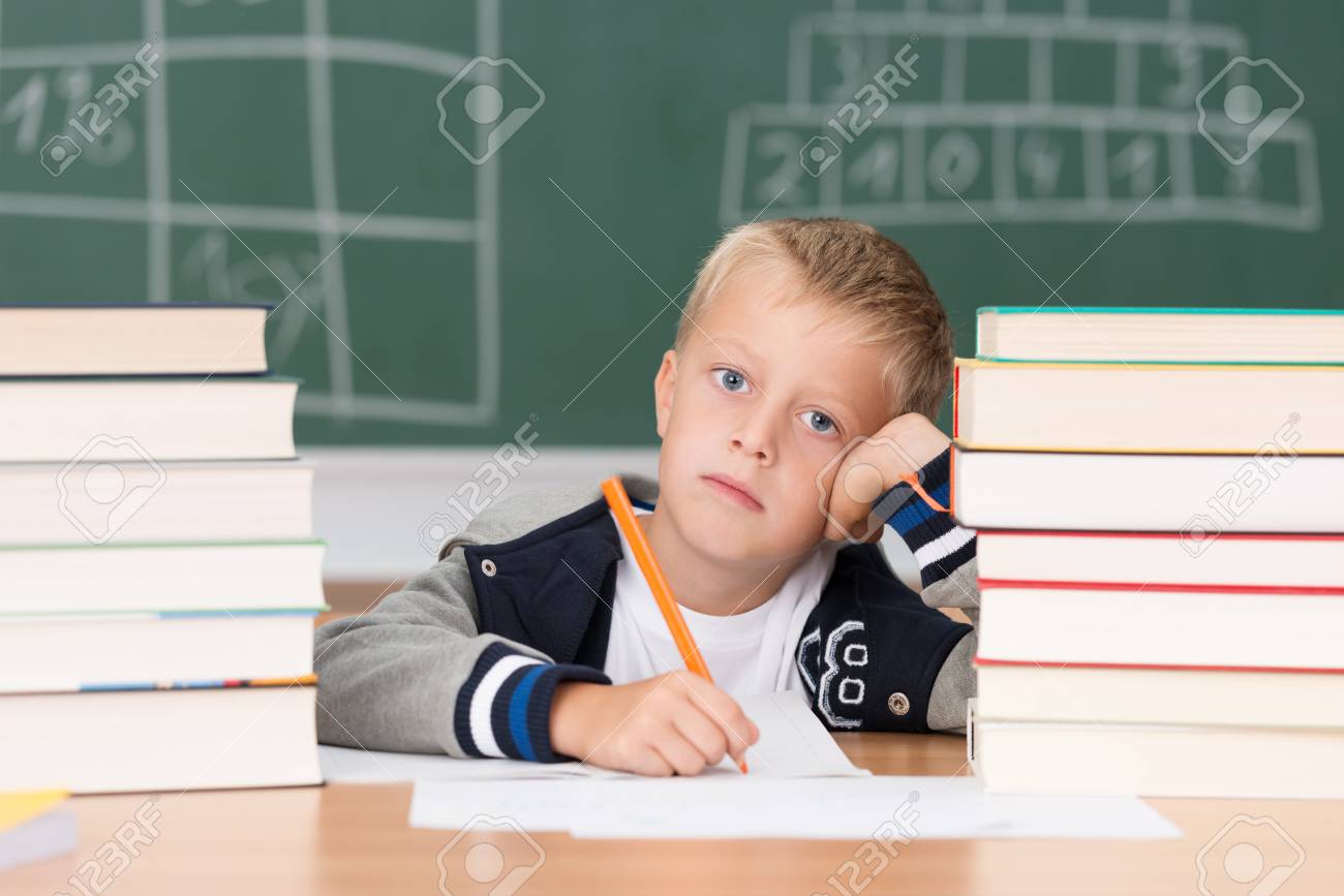 Dejected little boy in class in school